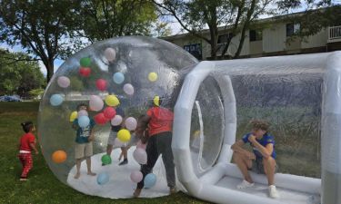 Child standing inside a giant inflatable snow globe