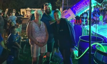 Group enjoying a foam party at night with glow lights