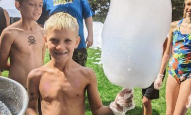 Kids eating pink cotton candy at a party