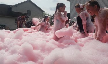 Kids splashing through foam at an outdoor party