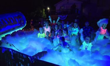 Nighttime glow foam party with children and adults