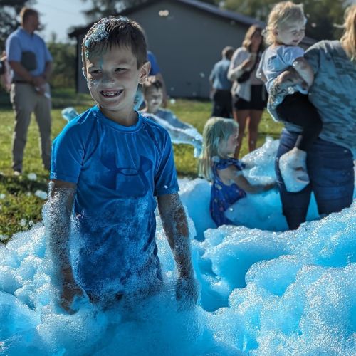 services. at a kids birthday party a boy playing in blue foam at a party in grand rapids michigan