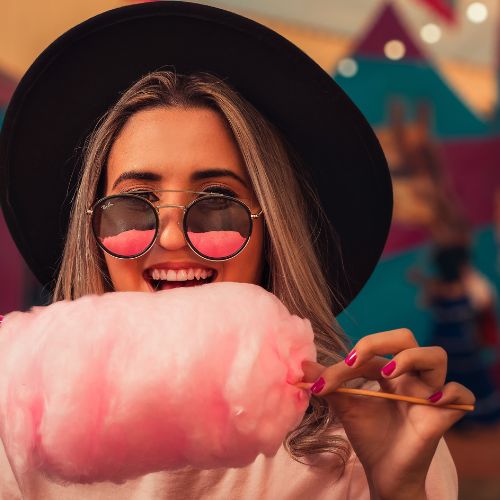 woman eating cotton candy on a stick