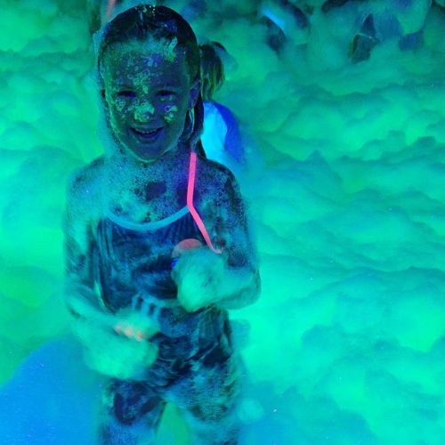 services. a girl playing in glow foam at a party